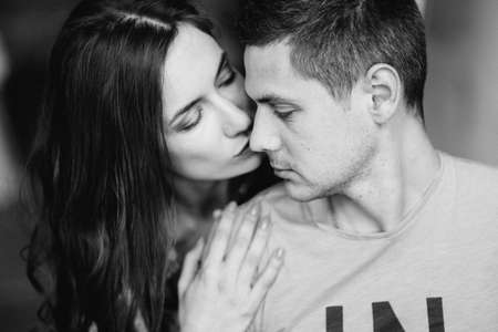 a guy and a girl sit on the bed in the room and look at each other