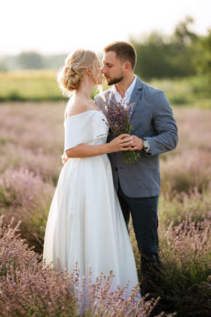 bride and groom on a walk in the lavender fieldの写真素材