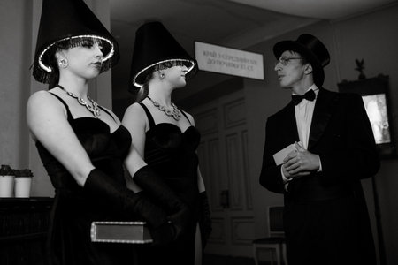 model girls in black dresses with illuminated floor lamps on their heads