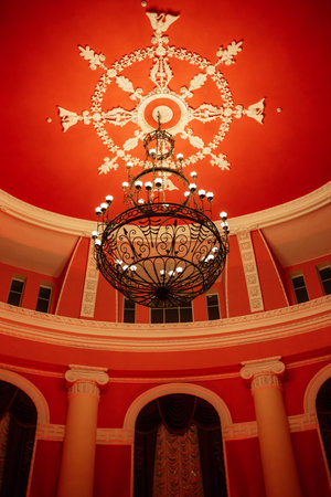 antique ceiling chandelier with lamps in red light on vaulted ceilingの写真素材