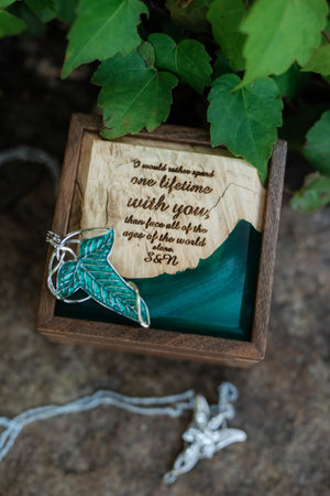 wedding invitation in a gray envelope on a table with green sprigs