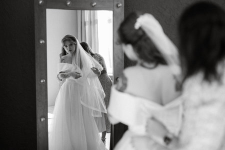 preparations for the bride with the dressing of the wedding dress in the studioの写真素材