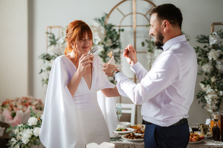 newlyweds happily cut, laugh and taste the wedding cake