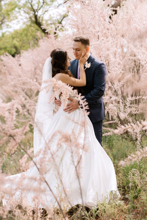 the groom and the bride are walking in the forest on a bright dayの写真素材