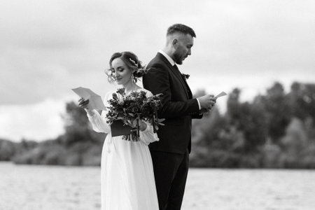 the first meeting of the bride and groom in wedding dresses on the pier near the waterの写真素材
