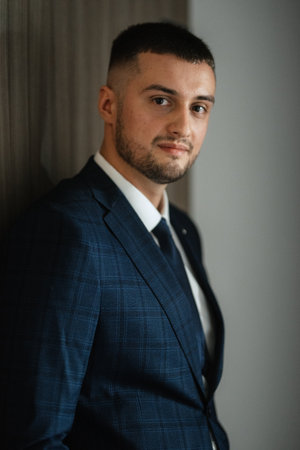 portrait of a bearded groom guy in a dark blue suit