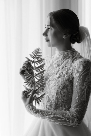 portrait of a bride in the morning before the wedding with putting on a white dressの写真素材