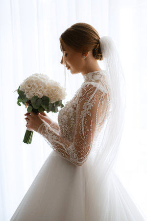portrait of a bride in the morning before the wedding with putting on a white dressの写真素材