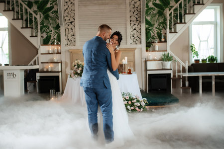 the first dance of the bride and groom inside a restaurant with heavy smokeの写真素材