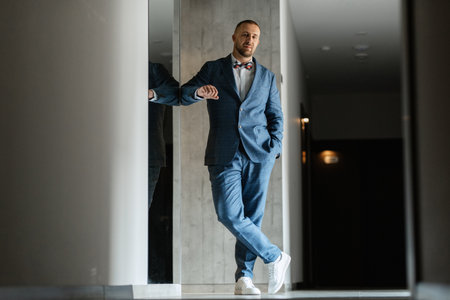 portrait of smiling groom with beard in blue color suitの写真素材