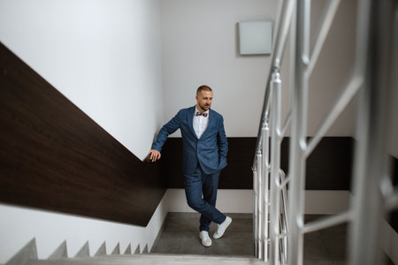 portrait of smiling groom with beard in blue color suitの写真素材