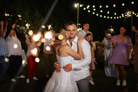 newlyweds at a wedding in the corridor of sparklersの写真素材