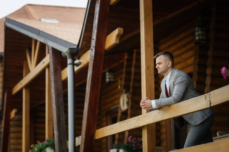 portrait of the groom in a gray suit and an orange vest and white sneakersの写真素材