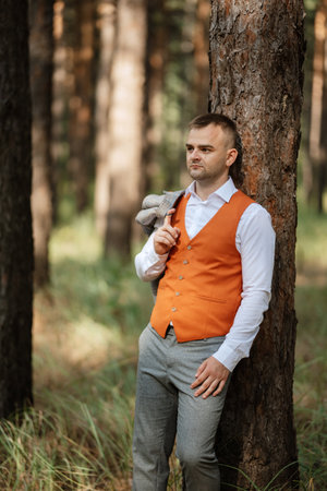 portrait of the groom in a gray suit and an orange vest and white sneakersの写真素材