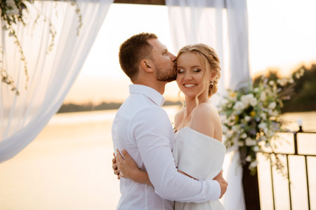 bride and groom against the backdrop of a yellow sunset on a pier near the riverの写真素材