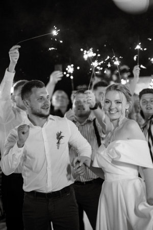 newlyweds at a wedding in the corridor of sparklersの写真素材