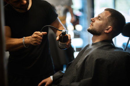 portrait of a young guy groom at the training camp in the barbershop with shaving and stylingの写真素材