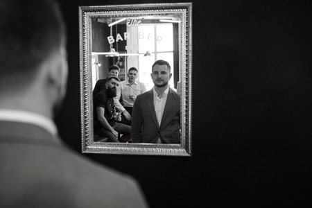 portrait of a young guy groom at the training camp in the barbershop with shaving and styling