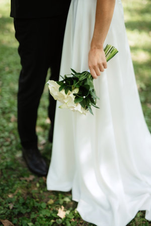 the first meeting of the bride and groom in wedding outfits in the parkの写真素材