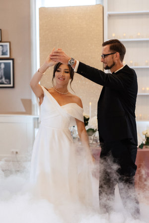 the first dance of the bride and groom inside a restaurant with heavy smokeの写真素材