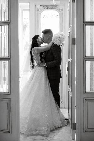 bride and groom inside a cocktail bar in a bright atmosphere with a glass of drinkの写真素材