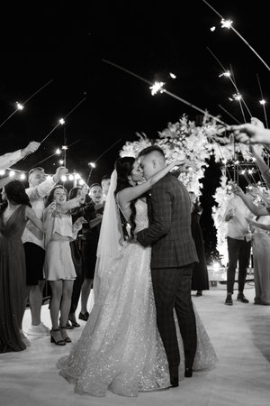 newlyweds at a wedding in the corridor of sparklersの写真素材