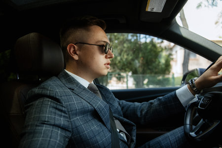 portrait of a groom in a gray suit driving a carの写真素材