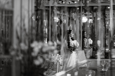portrait of a bride in a white dress in a bright cafe with mirrorsの写真素材