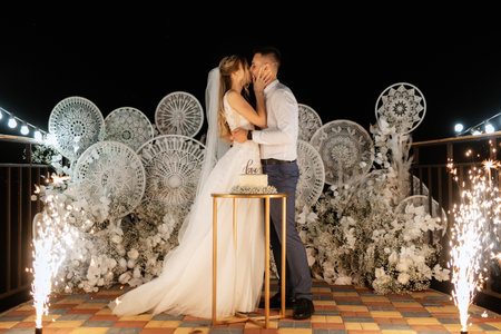 newlyweds happily cut, laugh and taste the wedding cakeの写真素材