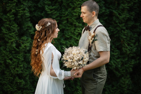 wedding walk of the bride and groom in a coniferous park in summerの写真素材