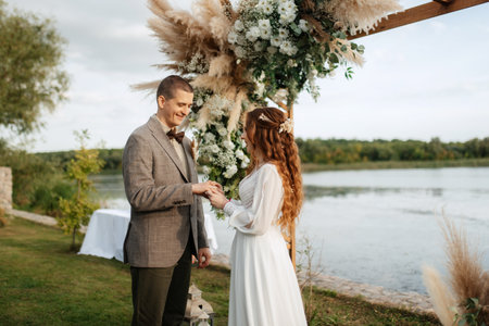 wedding ceremony of the newlyweds in a country cottage on a green hillの写真素材