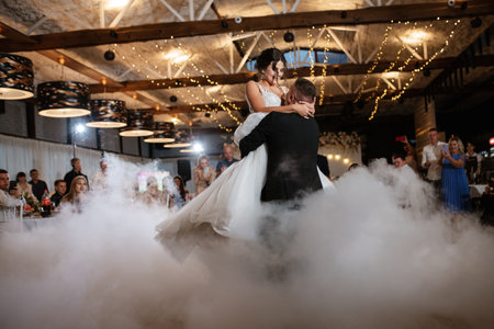 the first dance of the bride and groom inside a restaurant with heavy smokeの写真素材