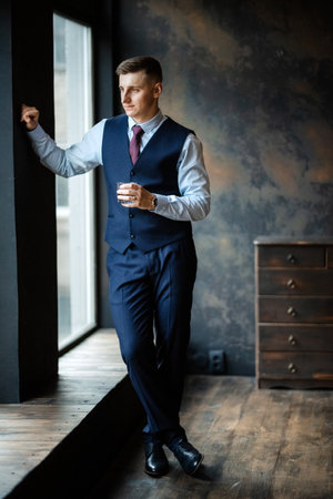 portrait of a cheerful groom in a blue suit in the studioの写真素材