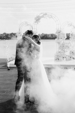 the first dance of the bride and groom inside a restaurant with heavy smokeの写真素材