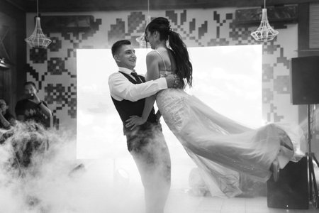 the first dance of the bride and groom inside a restaurant with heavy smokeの写真素材