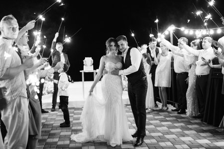 newlyweds at a wedding in the corridor of sparklersの写真素材