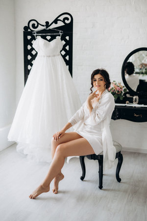 black-haired bride girl getting ready for groom in boudoir with bathの写真素材
