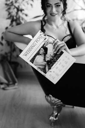 black-haired bride girl getting ready for groom in boudoir with bathの写真素材