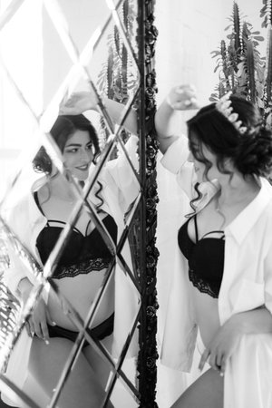 black-haired bride girl getting ready for groom in boudoir with bathの写真素材