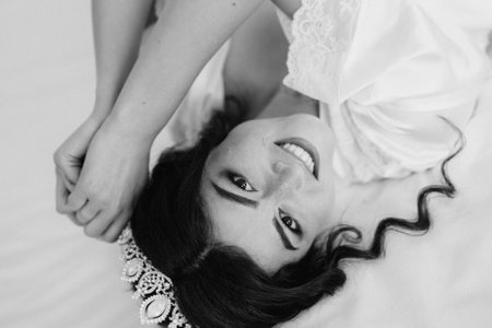 black-haired bride girl getting ready for groom in boudoir with bathの写真素材