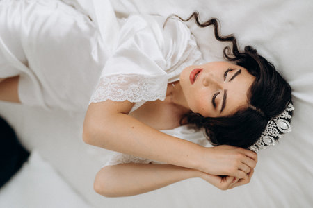 black-haired bride girl getting ready for groom in boudoir with bathの写真素材