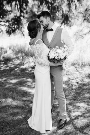 guy and a girl newlyweds are walking in the forest in summerの写真素材