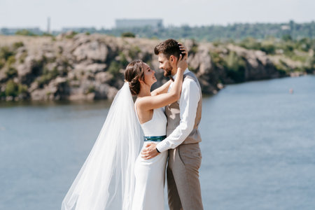 bride blonde girl and groom near the river at sunset lightの写真素材