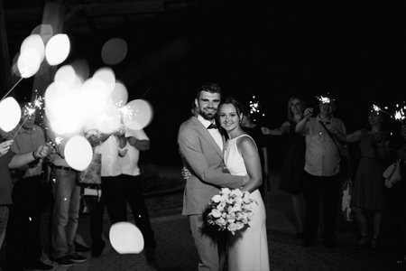 newlyweds at a wedding in the corridor of sparklersの写真素材