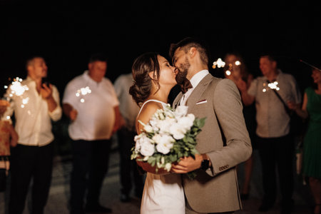 newlyweds at a wedding in the corridor of sparklersの写真素材
