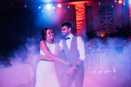 the first dance of the bride and groom inside a restaurant with heavy smokeの写真素材