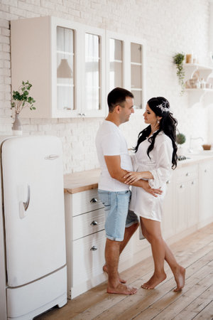young couple guy and girl in a large kitchen in the morningの写真素材