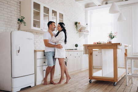 young couple guy and girl in a large kitchen in the morningの写真素材