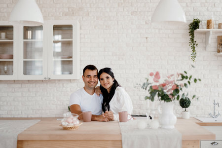 young couple guy and girl in a large kitchen in the morningの写真素材
