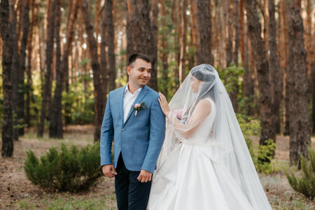 the first meeting of the bride and groom in wedding outfits in the parkの写真素材